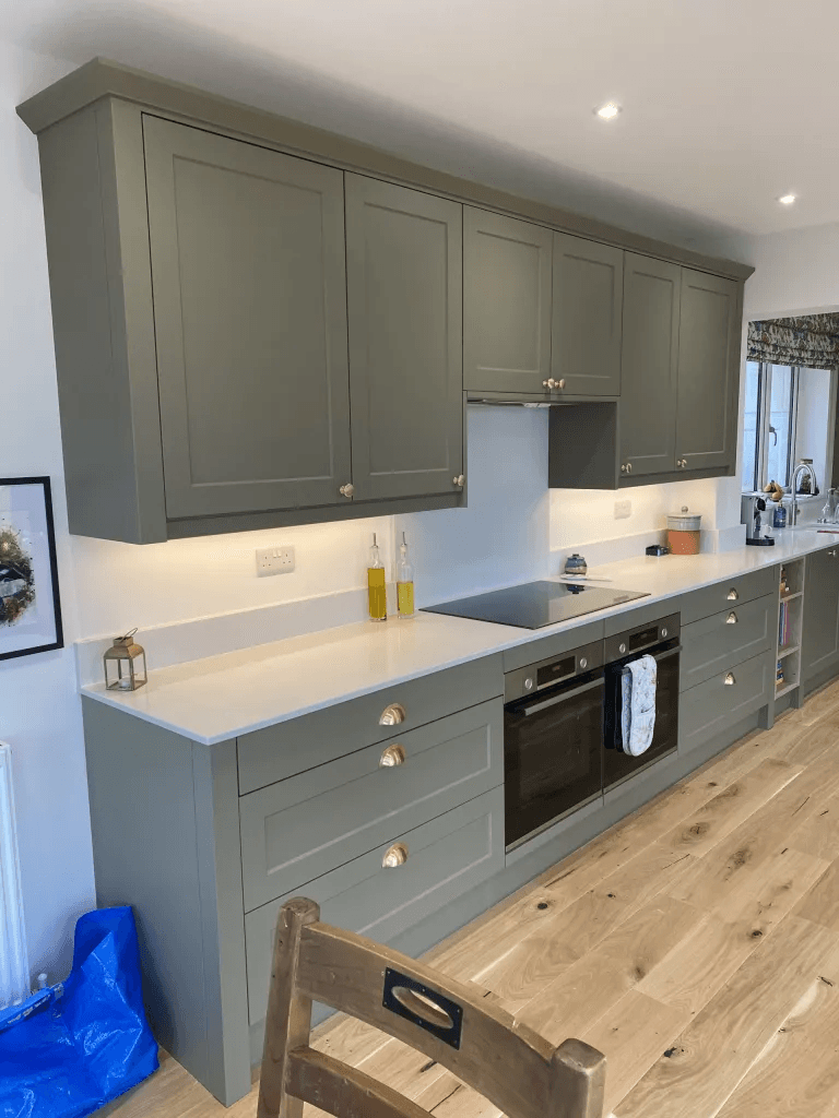 A TJO fitted kitchen with green cabinetry and brass handles