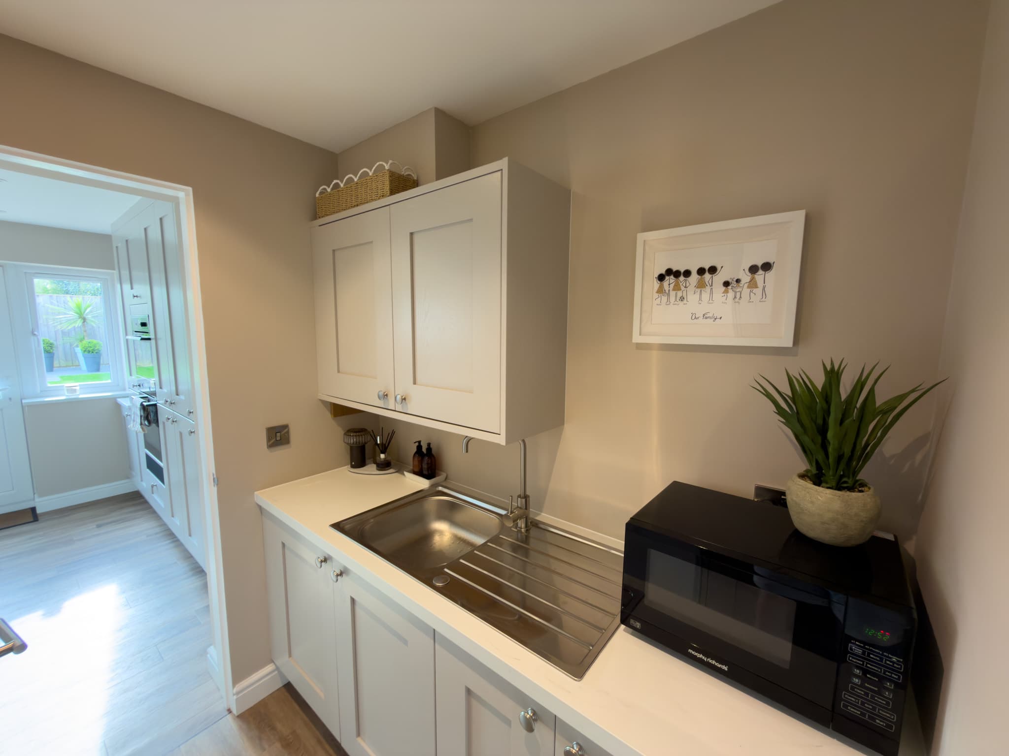 A fitted utility room with shaker cabinetry and a sink